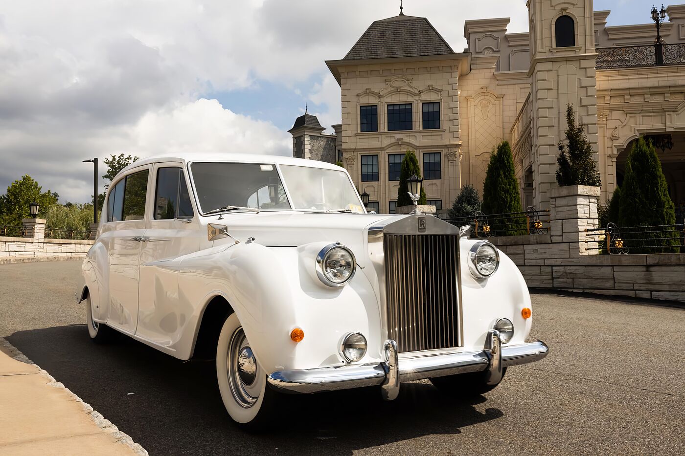 White vintage Rolls-Royce Princess wedding limousine waiting on the drive of a New Jersey ch&acirc;teau estate